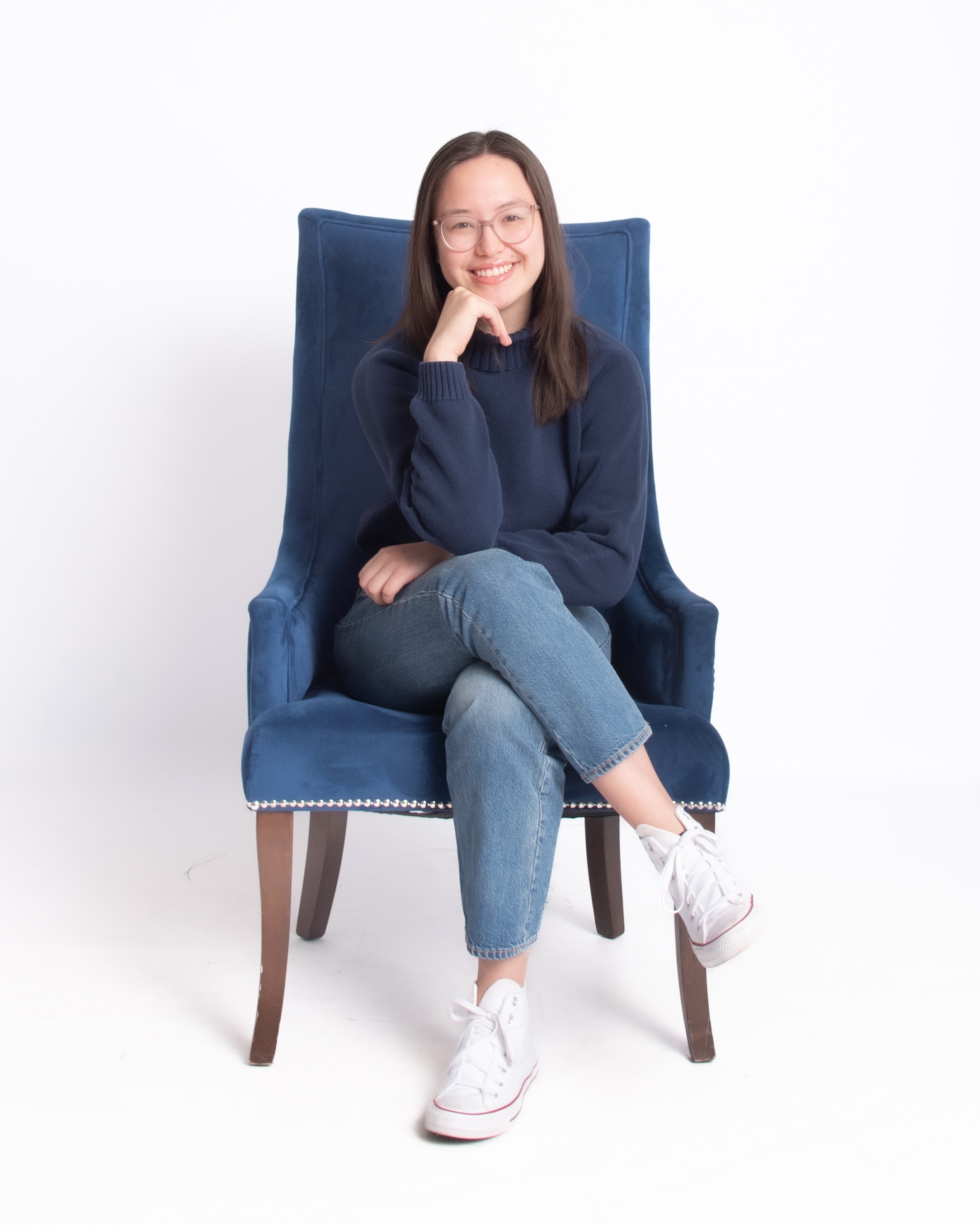 Mandy sitting on a blue chair.